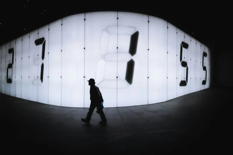 A man walking past a large display of numbers