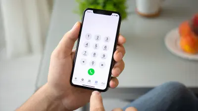 A person holding a phone about to dial a number