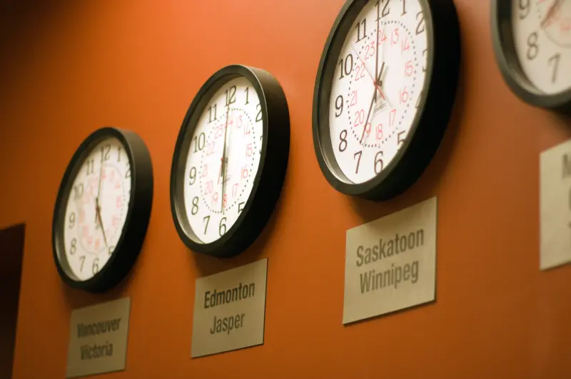 Analogue clocks representing different time zones on a wall