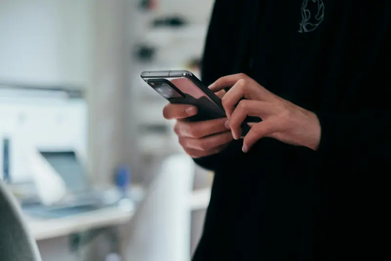 A young man holding a modern smartphone